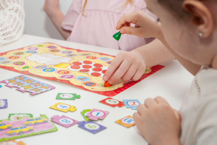 a,kindergarten,teacher,plays,a,board,game,with,two,little